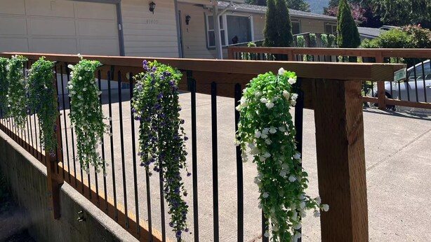 Un quartier résidentiel avec une clôture en bois, des jardinières suspendues et une porte de garage.