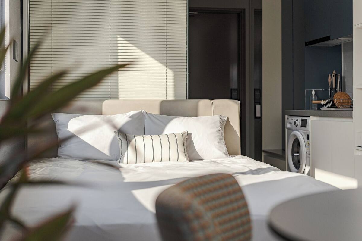 Ein modernes Schlafzimmer mit einem Bett, einer Waschmaschine und einem kleinen Tisch.