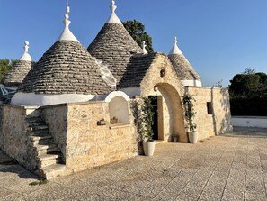 A stone building with multiple conical roofs and an arched entrance. - The beauty of nature, Comfort of facilities, Free Wi-Fi Pets allowed (Martina Franca)