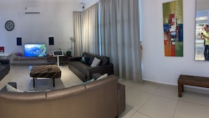 Een moderne woonkamer met een trap, een eethoek en een televisie.