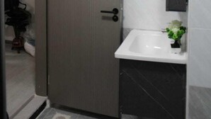 Ein Badezimmer mit Tür, Waschbecken und Spiegel.