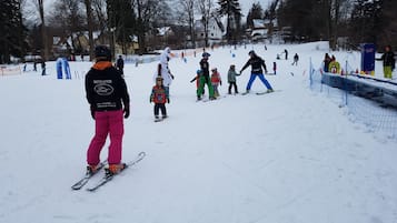 A snowy ski slope with skiers and snowboarders.