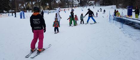 Una pista de esquí nevada con esquiadores y snowboarders.