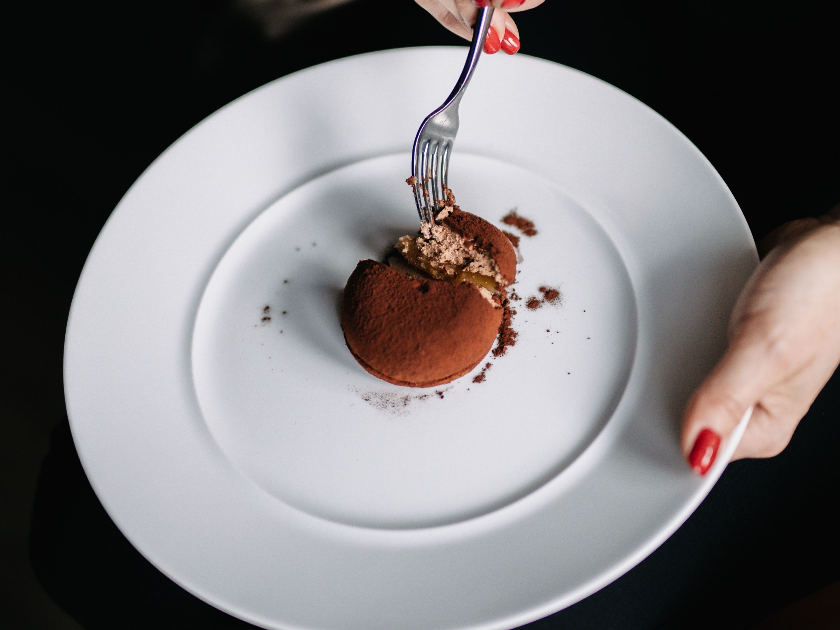 A white plate with a dessert on a dark background.