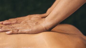 A close-up of hands performing a massage on a person's back.