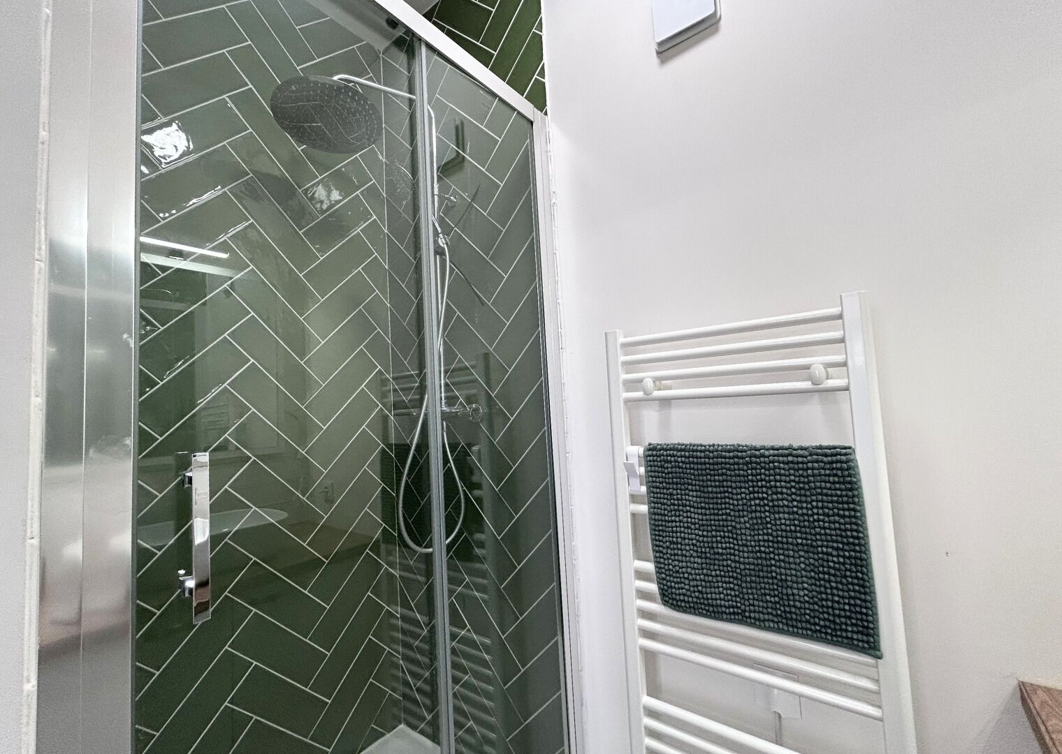 Eine Dusche mit Glastür und Handtuchhalter mit Handtuch.