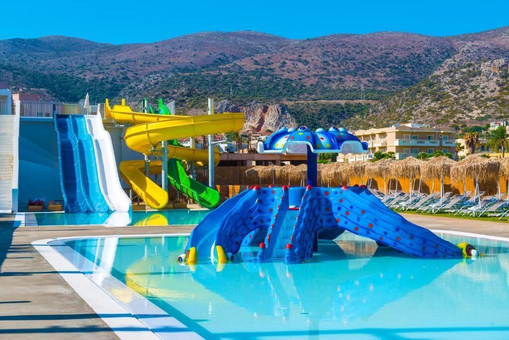 Ein Schwimmbad mit mehreren Wasserrutschen und einem Wasserparkbereich.