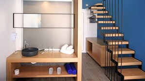 A modern bathroom with a wooden vanity, a black sink, and a glass shower enclosure. - Meropi Hotel (Hersonissos)