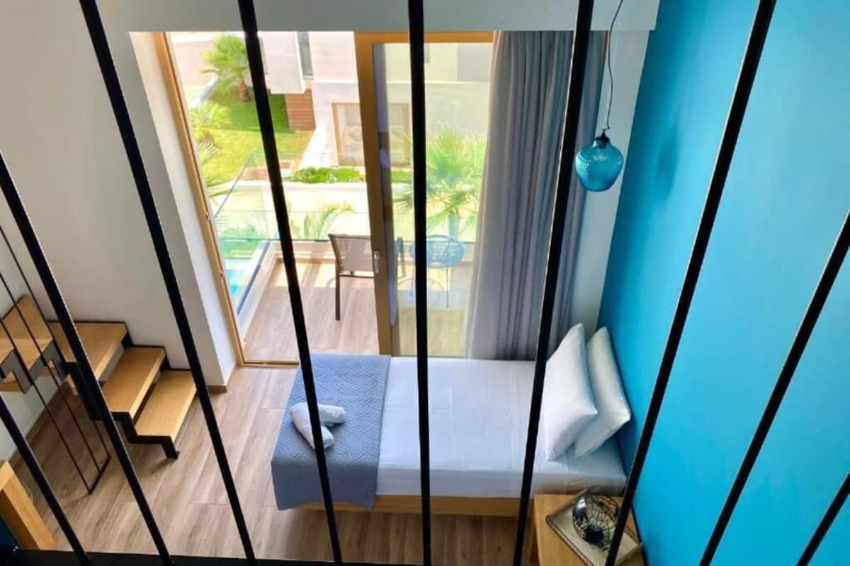 A bedroom with a bed, a window, and a view of the outdoors.