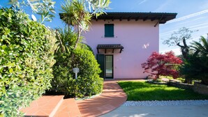 Un edificio rosa con un sendero de baldosas que conduce a la entrada.