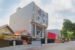 A multi-story building with a modern facade, featuring large windows and a mix of brick and stone materials. - OYO Life 1830 Mandala Residence (Jakarta)