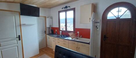 Una cocina con techo de madera, una mesa de comedor y vistas a través de una ventana.