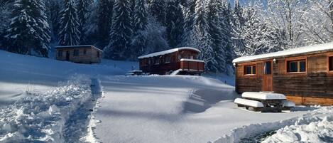 A snow-covered landscape with wooden cabins and a clear sky.