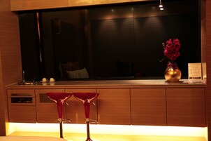 Una cocina moderna con armarios de madera, un ventanal grande y dos taburetes de bar.