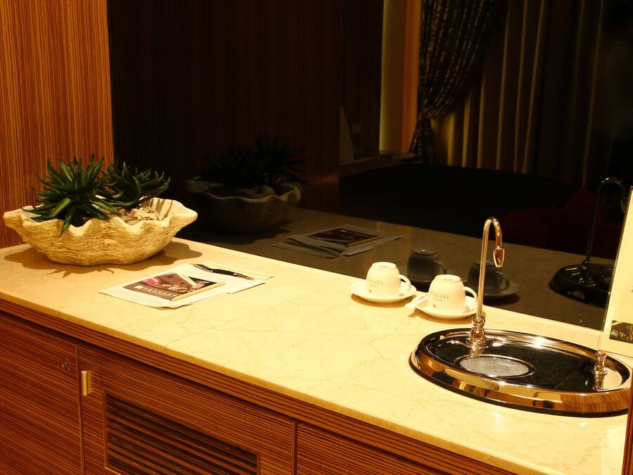 A bathroom with a sink, mirror, and wooden cabinets.