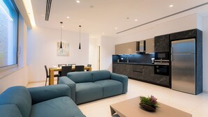 Una cucina moderna con mobili scuri, forno integrato e frigorifero in acciaio inossidabile.