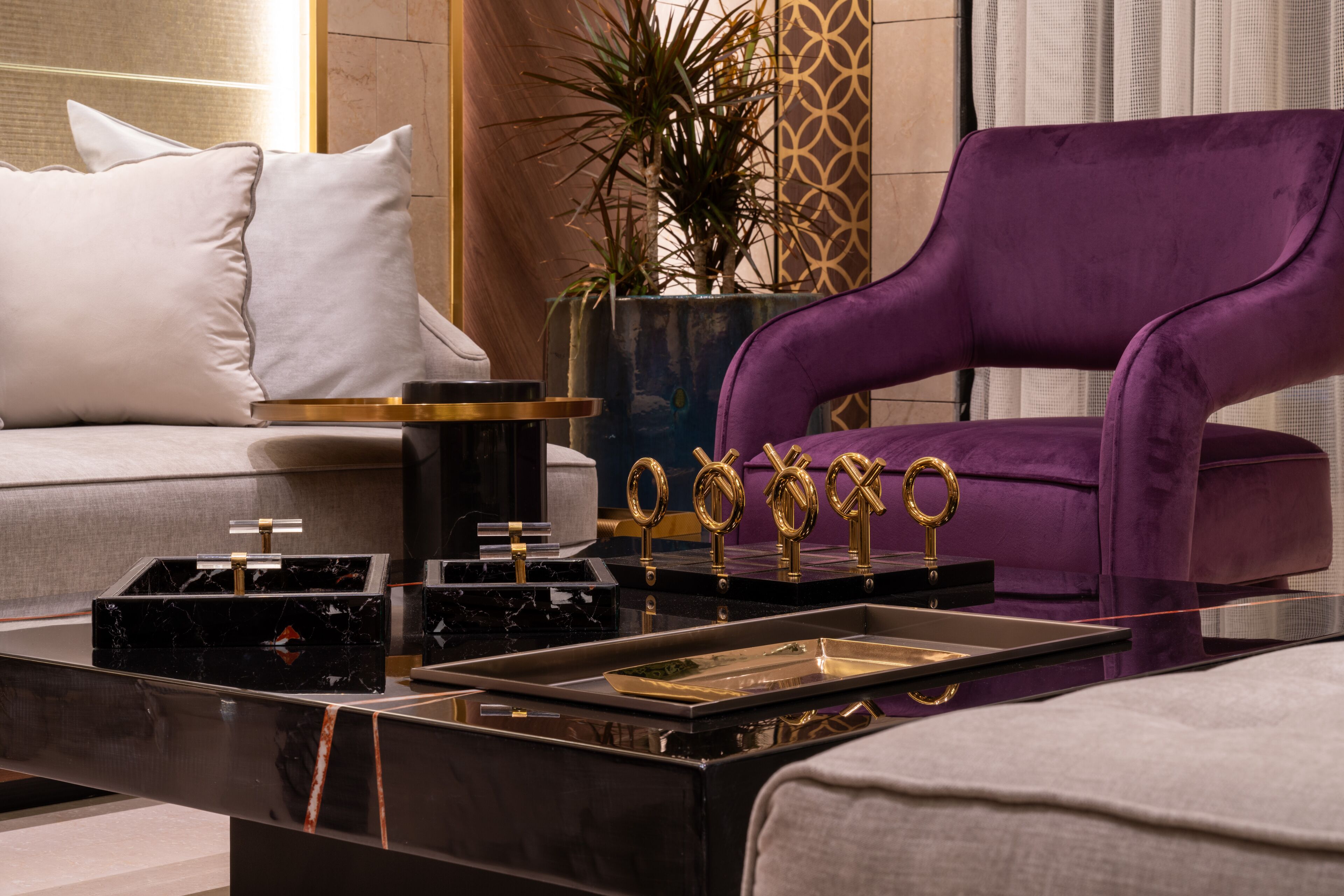 A modern living room with a purple sofa, a black marble coffee table, and a grey couch.