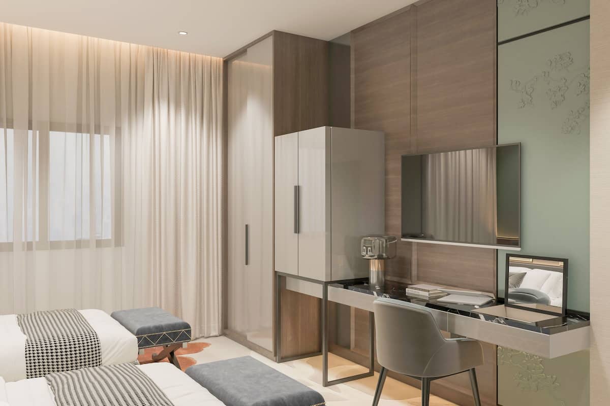 A modern bedroom with a bed, a desk, and a chair. There is a wardrobe and a mirror on the wall.