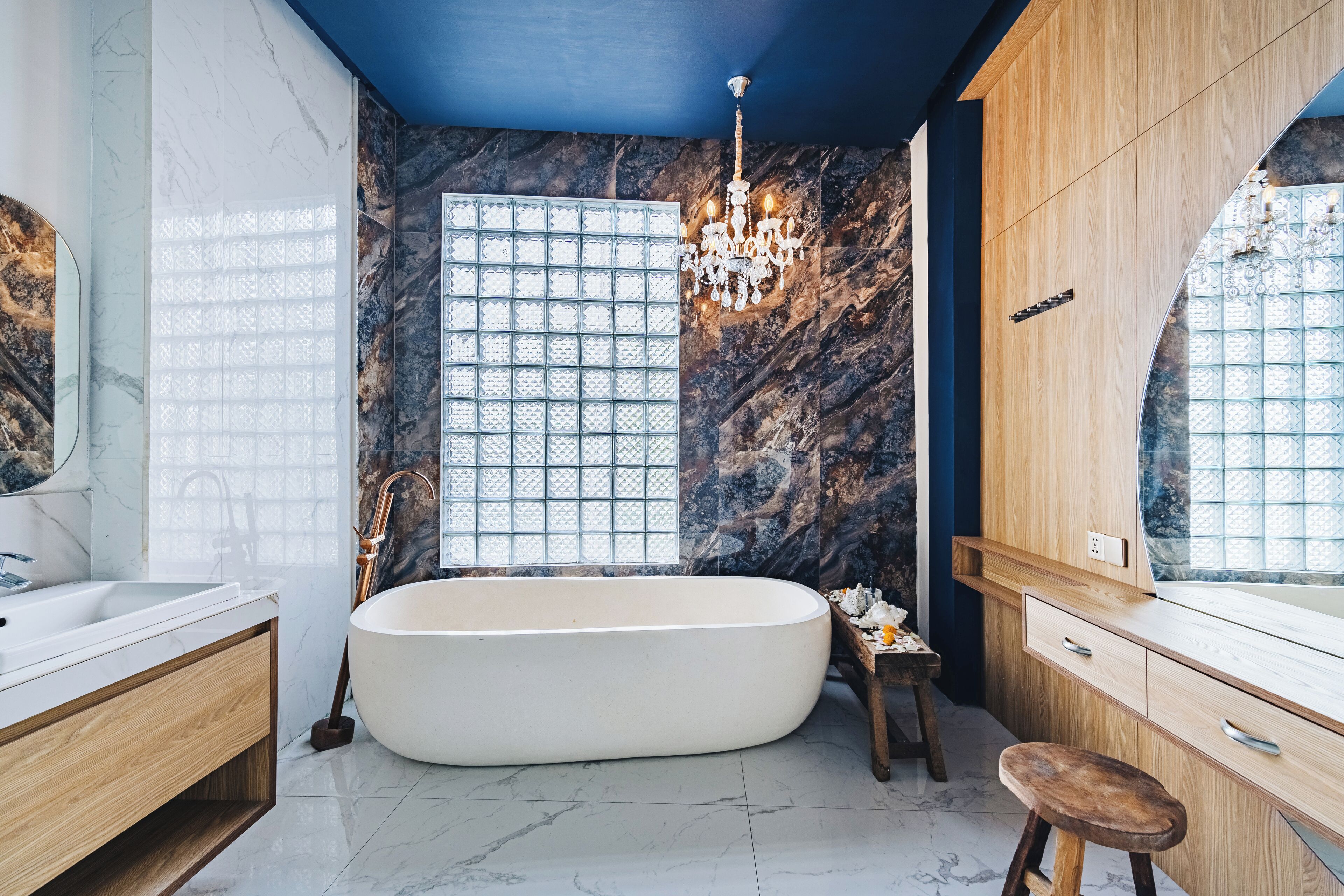 Une salle de bain moderne avec une baignoire sur pieds, un meuble-lavabo en bois et une grande fenêtre à carreaux.