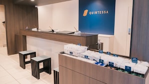 A reception area with a wooden counter, a blue sign with the name 'QUINTESSA', and a display of toiletries. -  Quintessa Hotel Chiba Funabashi (Funabashi)