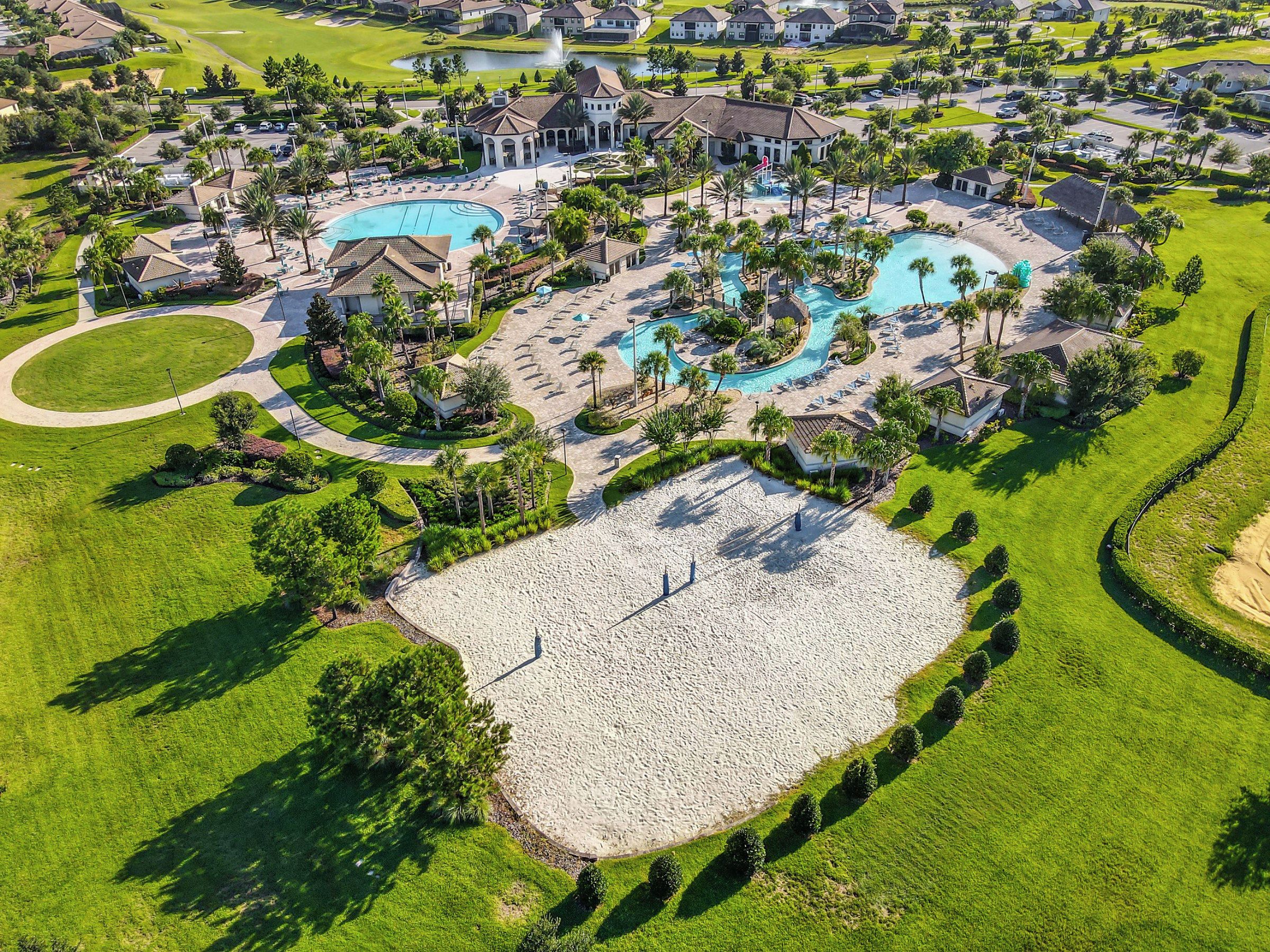 A golf course with a large pool area, multiple buildings, and well-maintained landscaping.