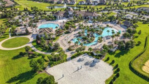 A golf course with a large pool area, multiple buildings, and well-maintained landscaping.