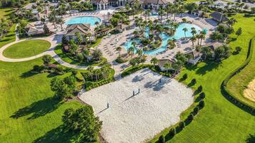 A golf course with a large pool area, multiple buildings, and well-maintained landscaping.