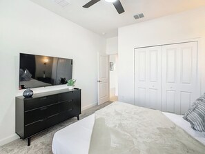 Un dormitorio con cama, cómoda, espejo y armario.