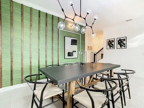 Un comedor con una mesa larga, sillas y una lámpara moderna.