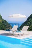 Una piscina al aire libre de temporada, sombrillas, tumbonas