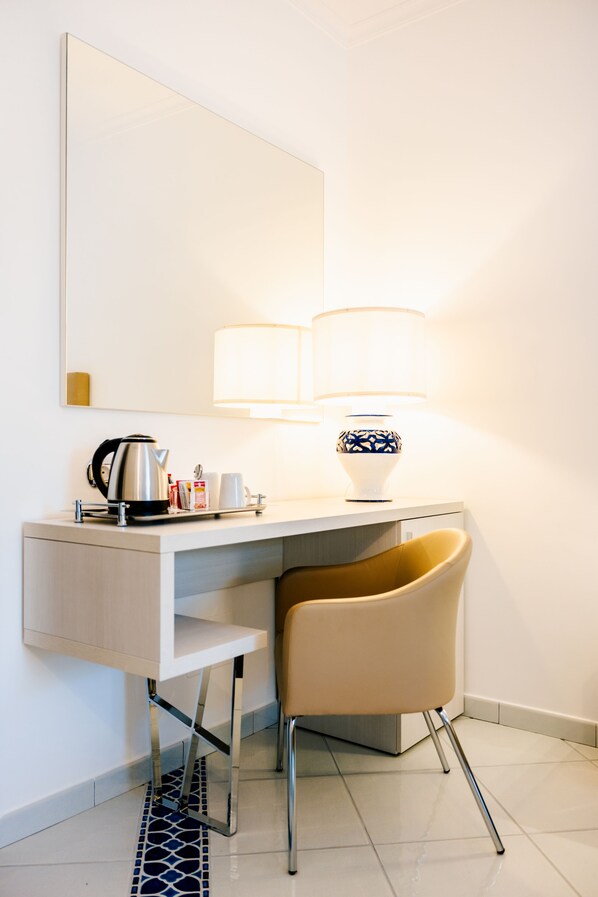 A hotel room with a desk, a chair, a lamp, and a kettle. - Villa Sant'Alfonso (Scala)