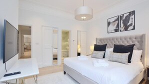 Une chambre d’hôtel avec un grand lit, une télévision et une armoire.