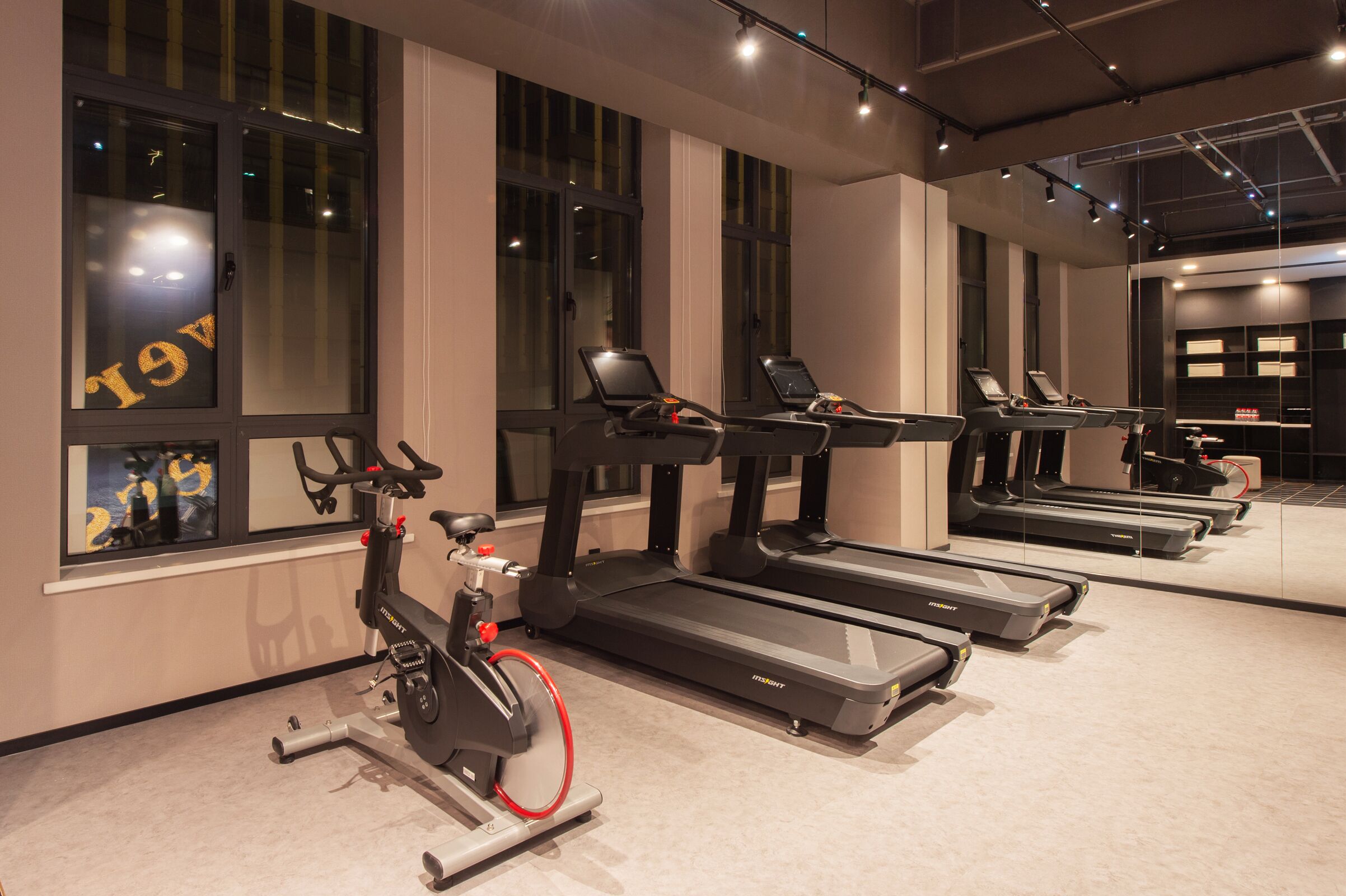 A gym with treadmills, an elliptical, and a stationary bike.
