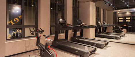 A gym with treadmills, an elliptical, and a stationary bike.