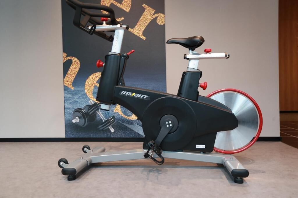 A stationary exercise bike with a black seat and handlebars, branded with "INSIGHT".