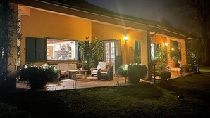 Un edificio con patio, mobiliario exterior y plantas en macetas.