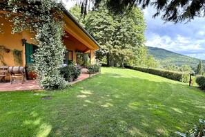 A house with a covered porch, a well-maintained lawn, and a mountain backdrop.