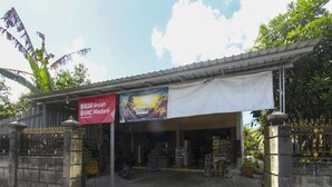 Ein Schaufenster mit einer Schautafel und einem Banner.