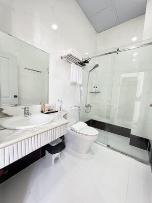Chambre exécutive double | Salle de bain | Douche, pomme de douche hydromassante, articles de toilette griffés