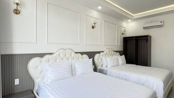 A modern bedroom with two beds, a wardrobe, and an air conditioning unit.