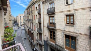 Una calle estrecha flanqueada por edificios de varios pisos, cada uno con balcones y ventanas.
