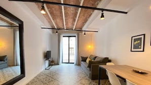 Una sala moderna con piso estampado, una mesa de comedor de madera y un sofá.