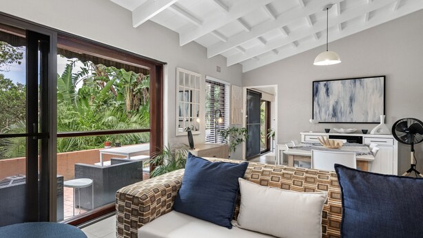 A modern living room with a sofa, a coffee table, and a TV area. - San Lameer Villa 2412 (Southbroom)