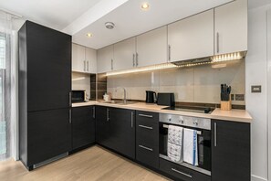 Enjoy cooking in this well-equipped kitchen with a stainless steel oven, microwave, and sink.