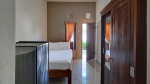 Una habitación de hotel con una cama, un armario y una televisión.
