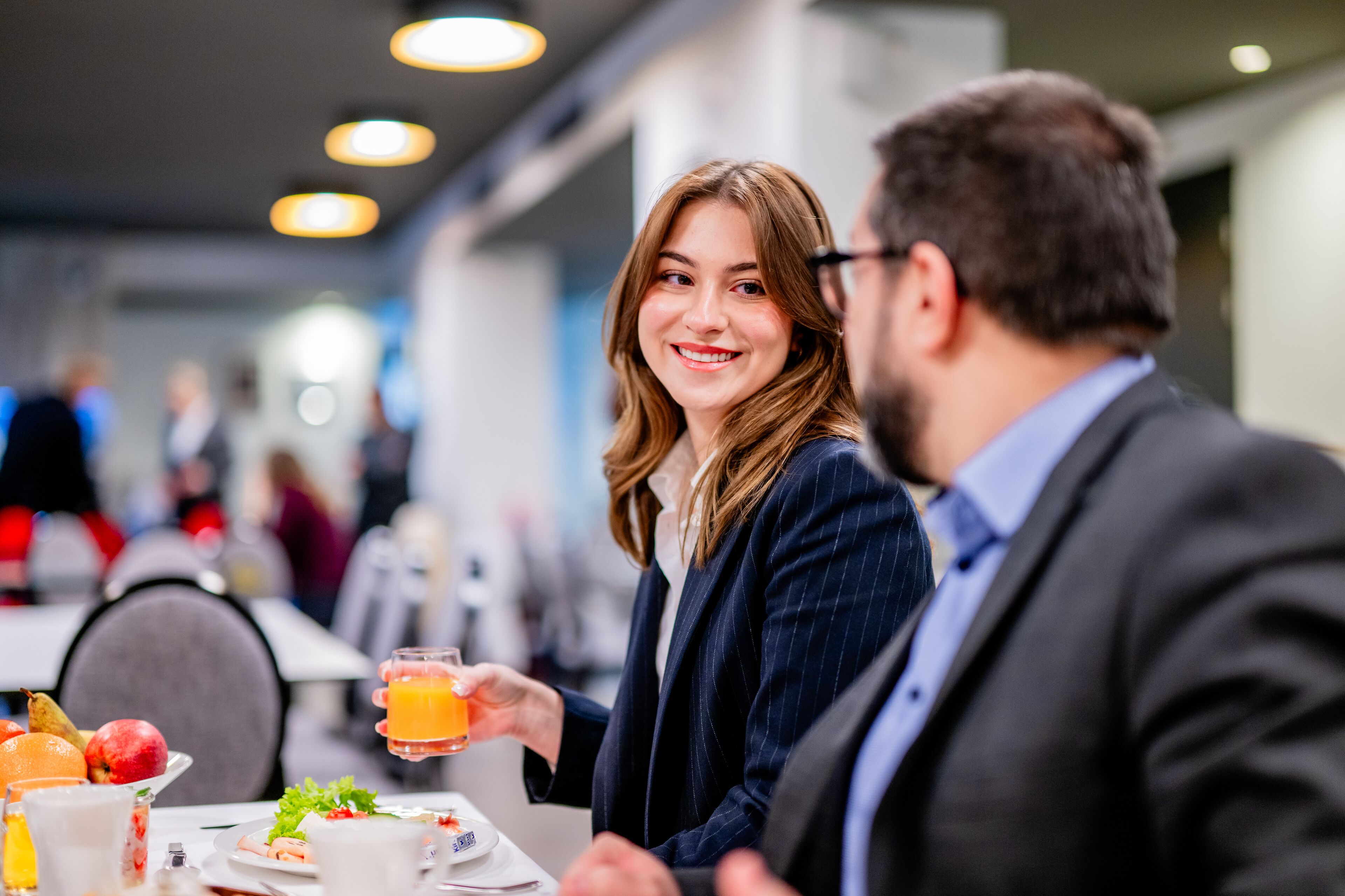 Un comedor con mesas, sillas y diversos alimentos.