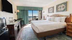 Ein Hotelzimmer mit Bett, Fernseher, Schreibtisch und Balkon mit Blick.