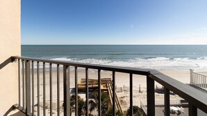 Un balcon avec vue sur l’océan et la plage.