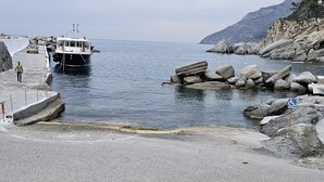 Una costa rocosa con un bote amarrado cerca de la orilla.