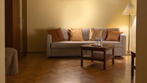 Ett vardagsrum med en soffa, ett soffbord och en lampa.